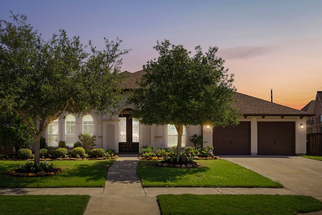 view of front of house featuring a lawn and a garage