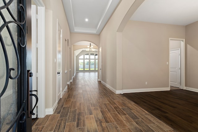 hall featuring dark hardwood / wood-style flooring and a chandelier