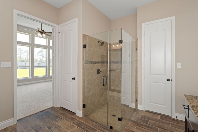 bathroom with ceiling fan, a shower with door, and vanity