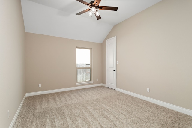 spare room with ceiling fan, light carpet, and vaulted ceiling