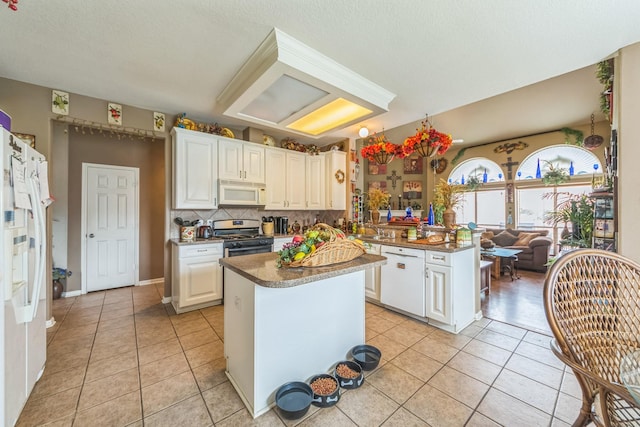 kitchen featuring kitchen peninsula, white appliances, and white cabinetry