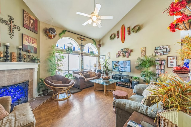 living room with a fireplace, hardwood / wood-style floors, high vaulted ceiling, and ceiling fan