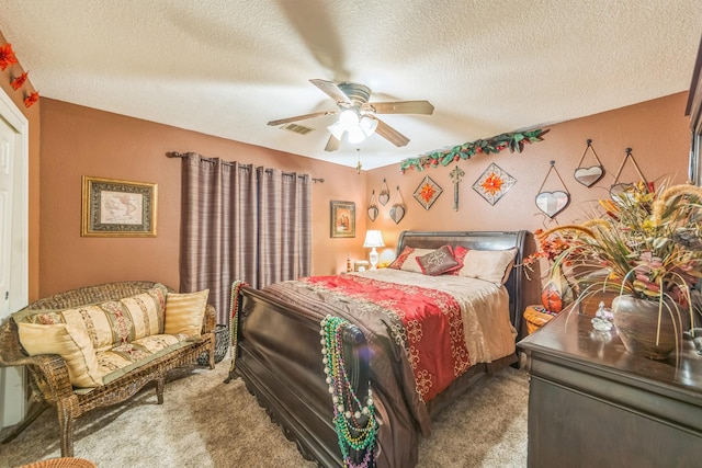 carpeted bedroom featuring ceiling fan and a textured ceiling