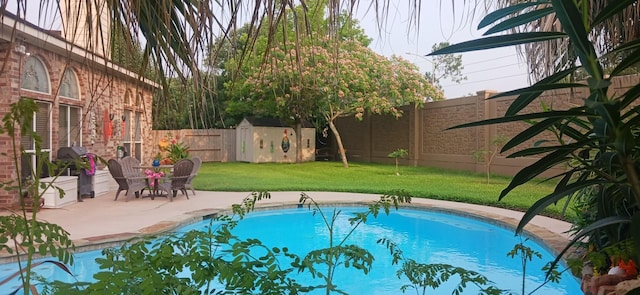 view of pool featuring a yard and a patio