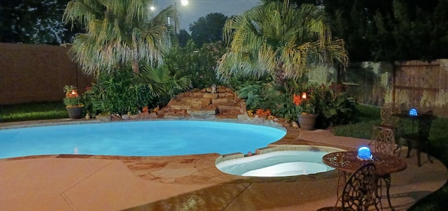 view of swimming pool with an in ground hot tub