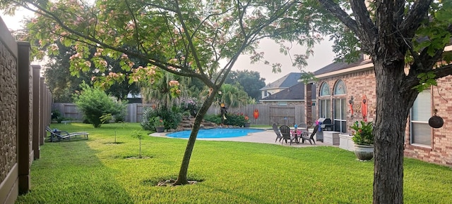 view of yard featuring a patio, a fenced backyard, and a fenced in pool