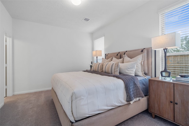 bedroom with light colored carpet and multiple windows