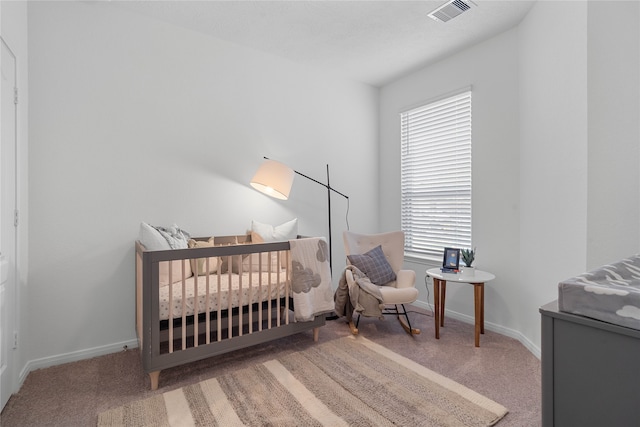 bedroom with a crib and carpet floors