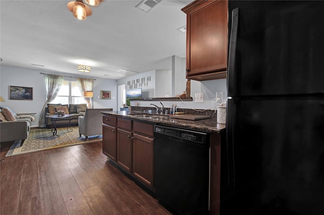 kitchen featuring dark hardwood / wood-style flooring, sink, dark stone countertops, and black appliances