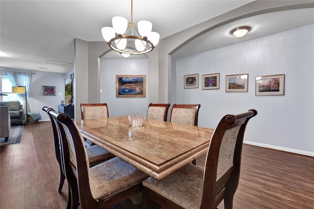 dining area with dark hardwood / wood-style flooring and a chandelier