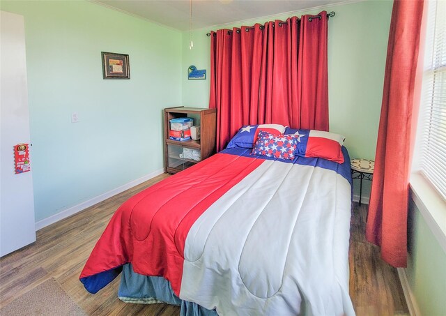 bedroom with hardwood / wood-style flooring and crown molding