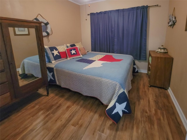 bedroom with ornamental molding and wood-type flooring