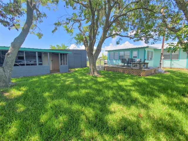 view of yard featuring a deck and a sunroom