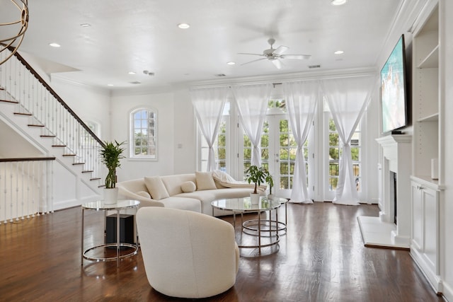 living room featuring dark wood-type flooring, ceiling fan, and ornamental molding