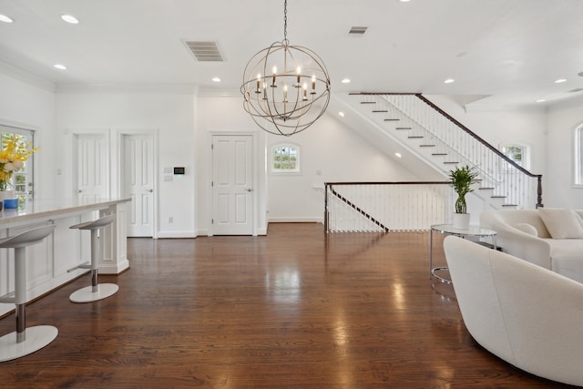 entryway featuring a wealth of natural light, wood-type flooring, and crown molding