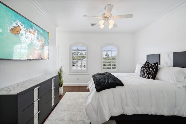 bedroom featuring dark hardwood / wood-style floors, ornamental molding, and ceiling fan