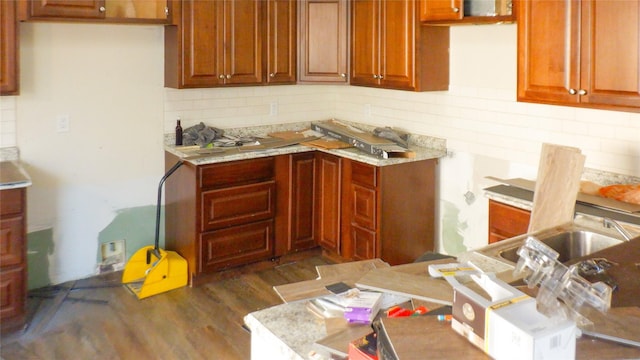 kitchen with dark hardwood / wood-style floors and light stone countertops