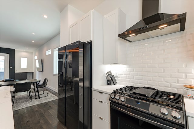 kitchen with wall chimney range hood, white cabinetry, dark hardwood / wood-style flooring, and black appliances