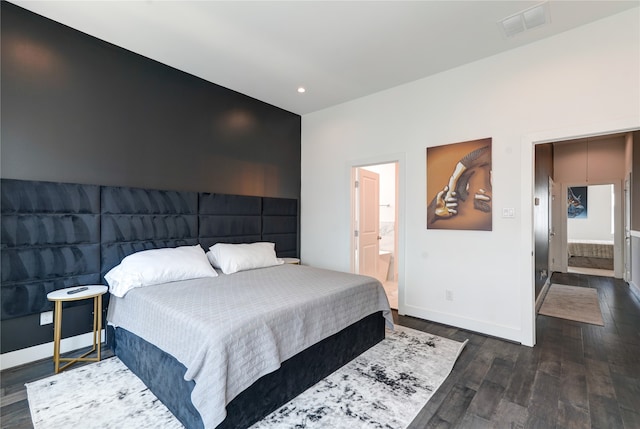 bedroom featuring dark hardwood / wood-style flooring and ensuite bathroom