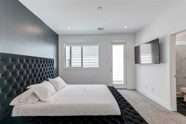 bedroom featuring ensuite bath and carpet floors