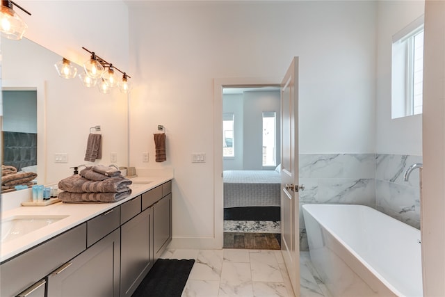 bathroom featuring a bath to relax in, dual vanity, tile flooring, and a wealth of natural light