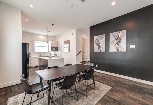 dining space with dark wood-type flooring and sink