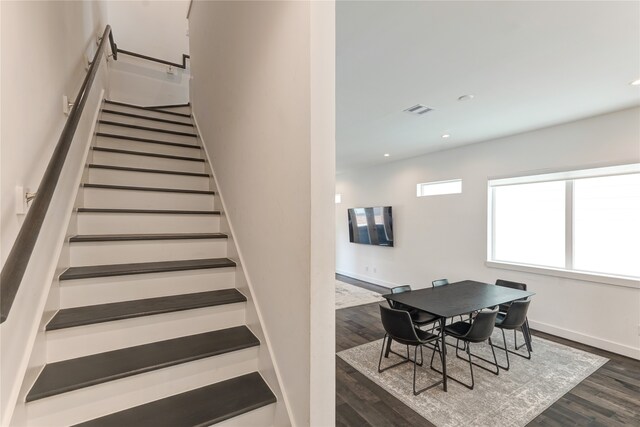 stairs with dark hardwood / wood-style flooring