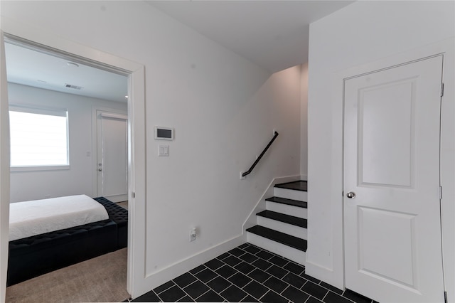 staircase featuring dark tile floors