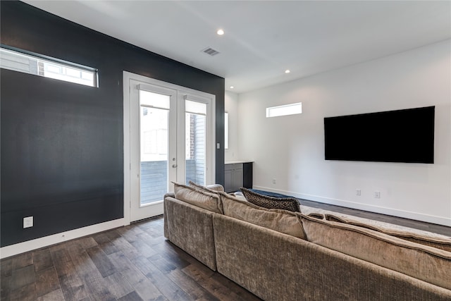 living room with a healthy amount of sunlight, french doors, and dark wood-type flooring