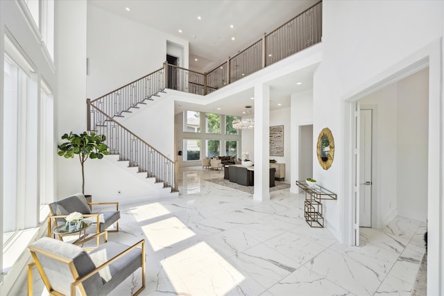 tiled foyer entrance featuring a towering ceiling and a notable chandelier