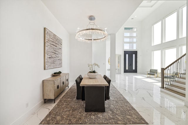 interior space with a towering ceiling, a chandelier, and light tile floors