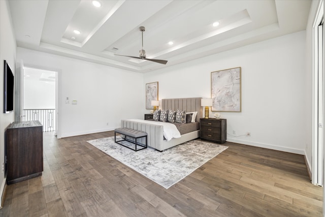 bedroom with a tray ceiling, ceiling fan, and dark hardwood / wood-style flooring