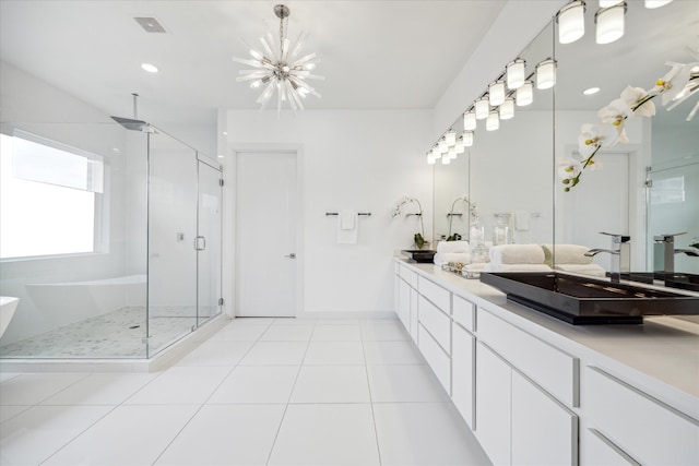 bathroom with tile floors, vanity with extensive cabinet space, shower with separate bathtub, and double sink