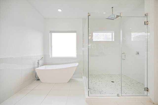 bathroom featuring tile walls, tile floors, and plus walk in shower