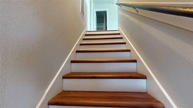 staircase with hardwood / wood-style flooring