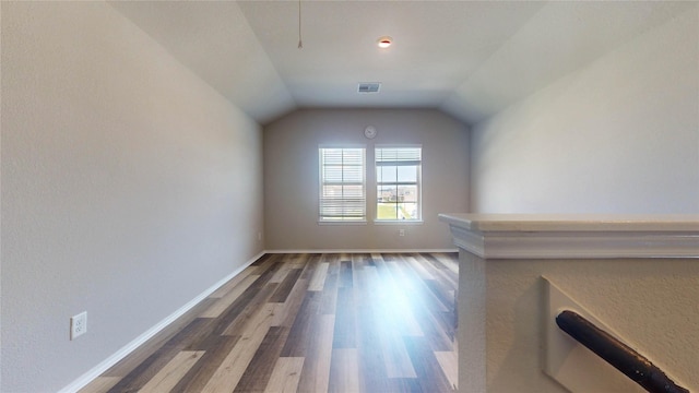 unfurnished living room featuring dark hardwood / wood-style flooring and vaulted ceiling