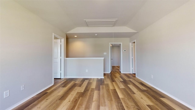 empty room with light hardwood / wood-style floors and lofted ceiling