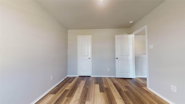 unfurnished bedroom with dark wood-type flooring