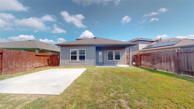 rear view of house featuring a lawn and a patio area