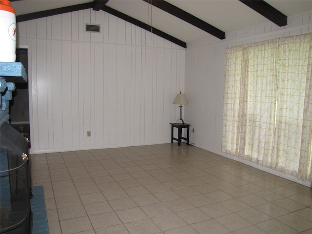 unfurnished living room with tile flooring and vaulted ceiling with beams