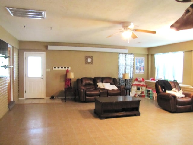 living room featuring plenty of natural light, tile flooring, and ceiling fan