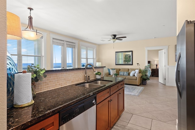 kitchen featuring ceiling fan, stainless steel appliances, backsplash, light tile floors, and sink