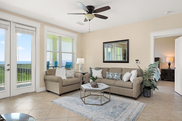 living room with french doors, ceiling fan, and light tile floors