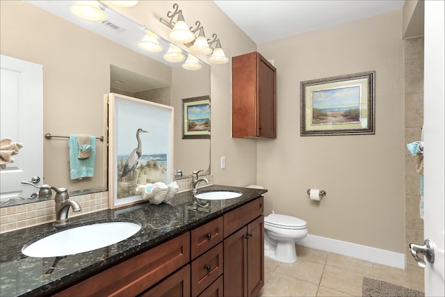 bathroom with double vanity, tile flooring, and toilet