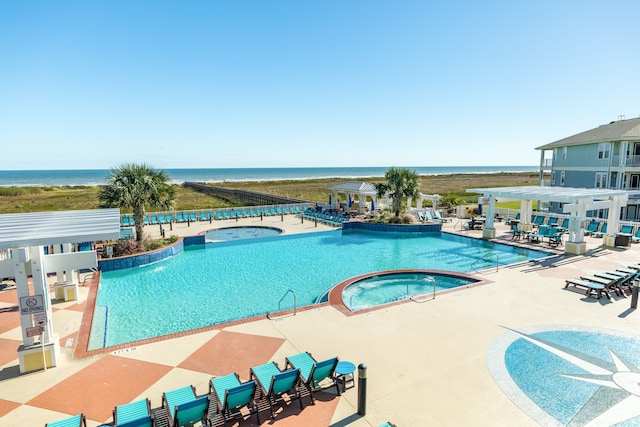 view of pool with a pergola, a water view, a patio, and a hot tub