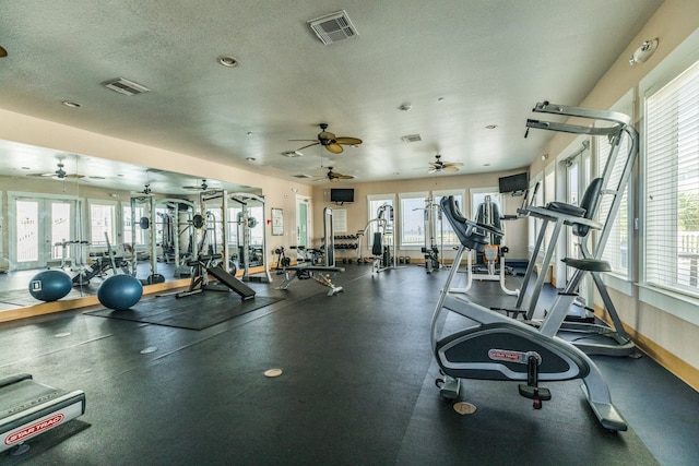 exercise room featuring a textured ceiling, ceiling fan, and french doors