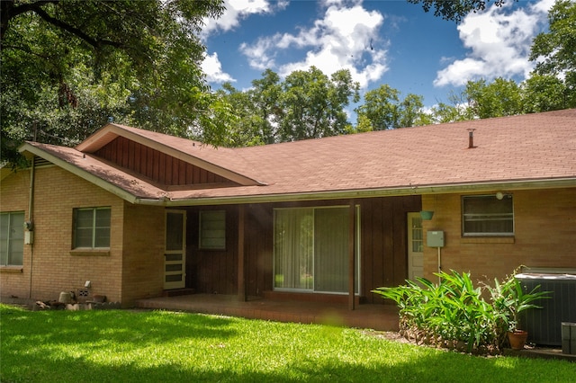 rear view of house featuring a yard, central AC unit, and a patio area