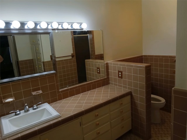 bathroom with decorative backsplash, vanity, tile patterned floors, tile walls, and toilet