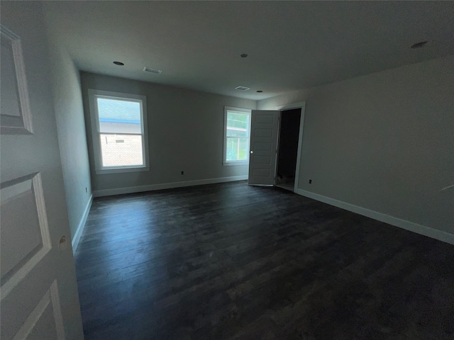 unfurnished room with a wealth of natural light and dark hardwood / wood-style floors