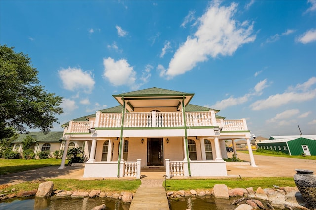 rear view of house featuring a balcony and a water view